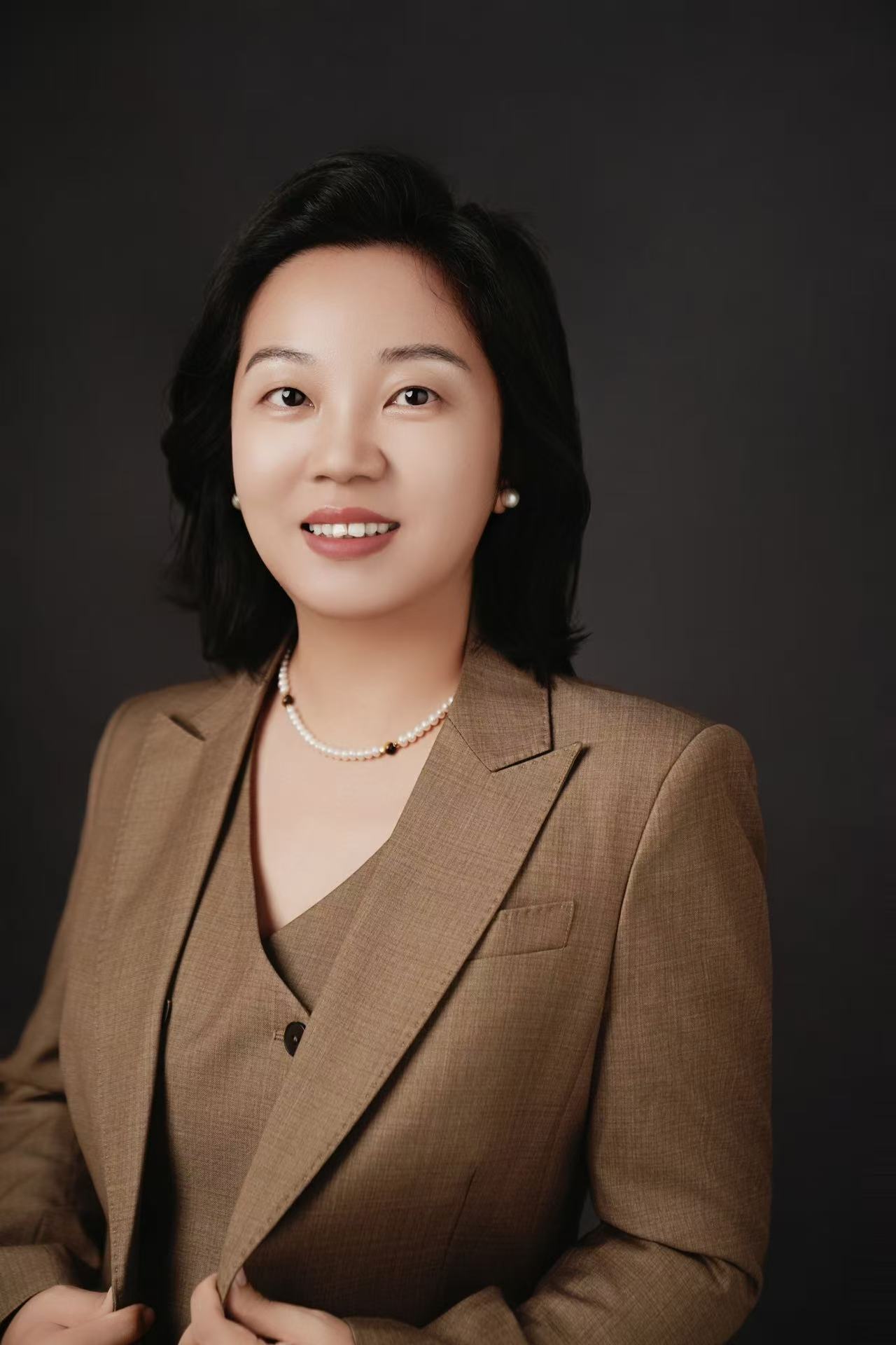 胡莹律师棕色西装半身职业形象照，客观展示律师个人职业形象。