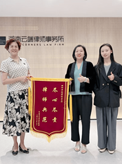 湖南云端律师事务所赠送锦旗团队合影,客观展示律所办公场景与团队服务形象;不据此推断案件结果。