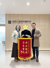 湖南云端律师事务所赠送锦旗团队合影，客观展示律所办公场景与团队服务形象；不据此推断案件结果。