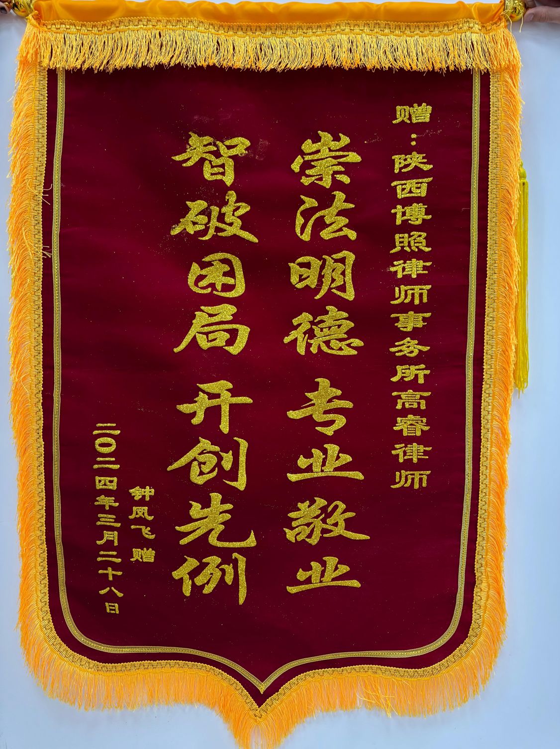 榆林律师事务所室内赠送锦旗合影，客观展示客户图片库中的服务场景。